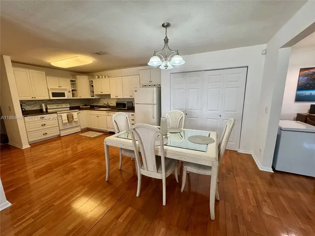 a view of a dining room with furniture a chandelier and wooden floor