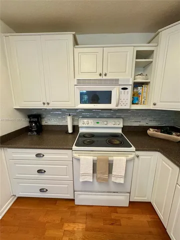 a stove top oven sitting inside of a kitchen