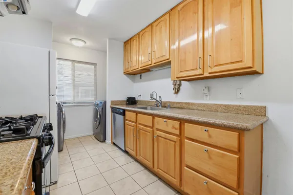a kitchen with granite countertop cabinets stainless steel appliances and a sink