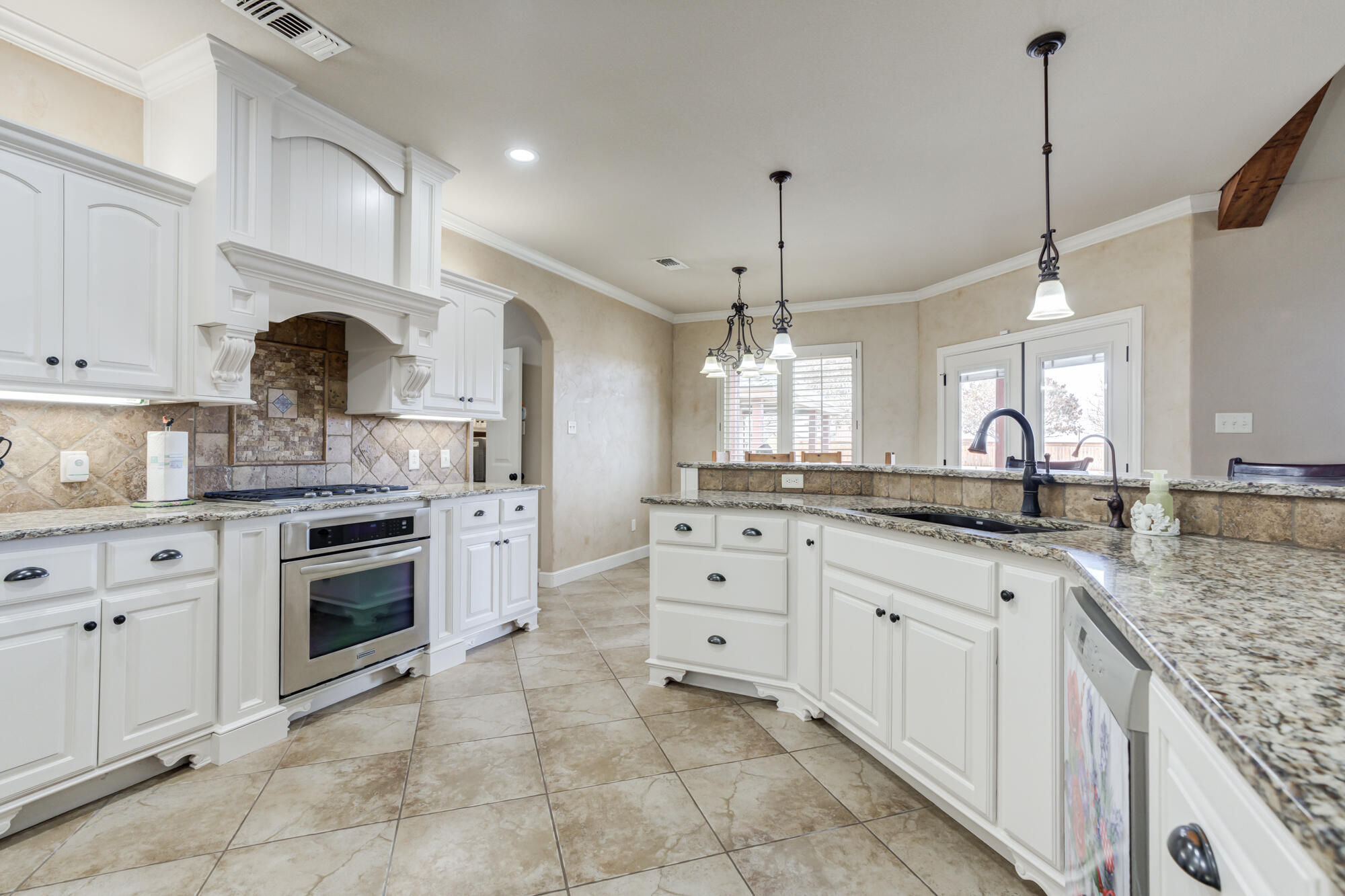 3206 County Road 7610 Lubbock, TX 79423 - Photo 19 of 93 a large kitchen with granite countertop a stove and a sink