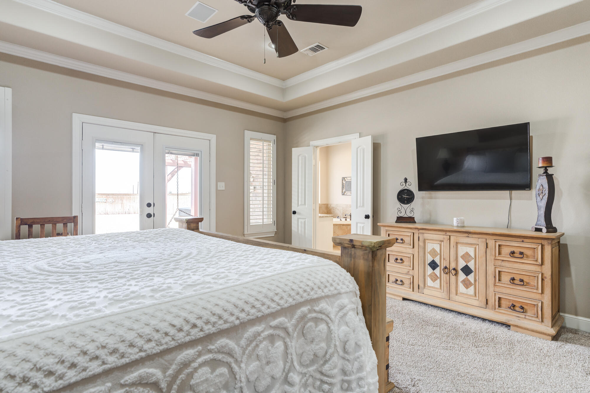 3206 County Road 7610 Lubbock, TX 79423 - Photo 29 of 93 a spacious bedroom with a bed and a flat screen tv