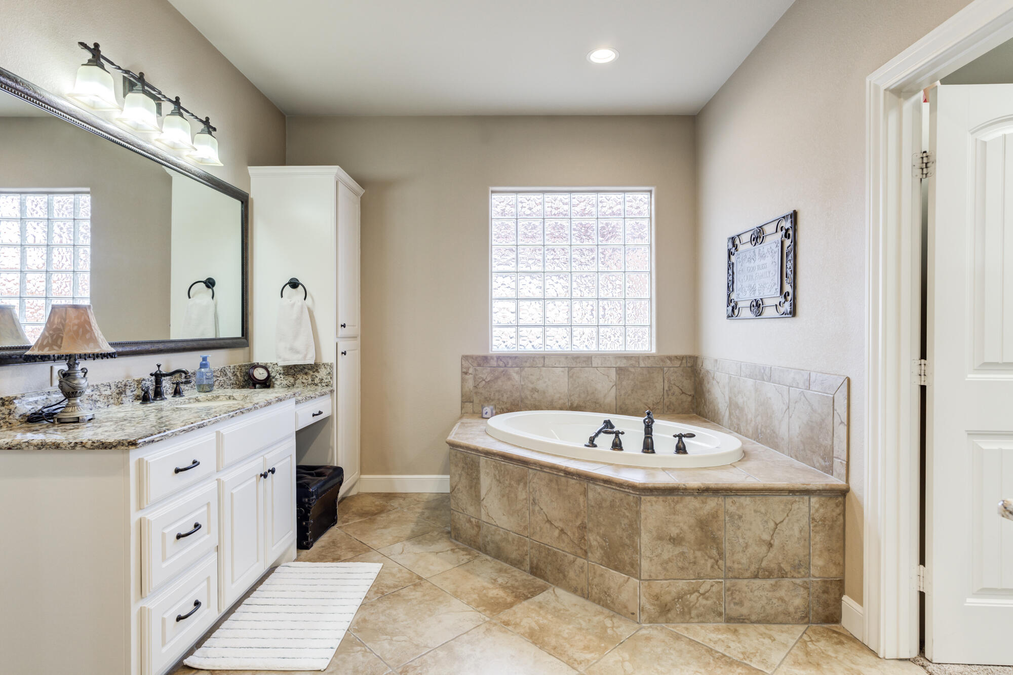 3206 County Road 7610 Lubbock, TX 79423 - Photo 30 of 93 a bathroom with a tub a sink double vanity and a mirror