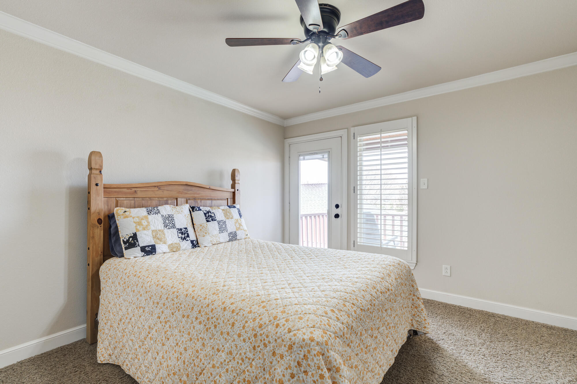 3206 County Road 7610 Lubbock, TX 79423 - Photo 44 of 93 a bedroom with a large bed and a chandelier