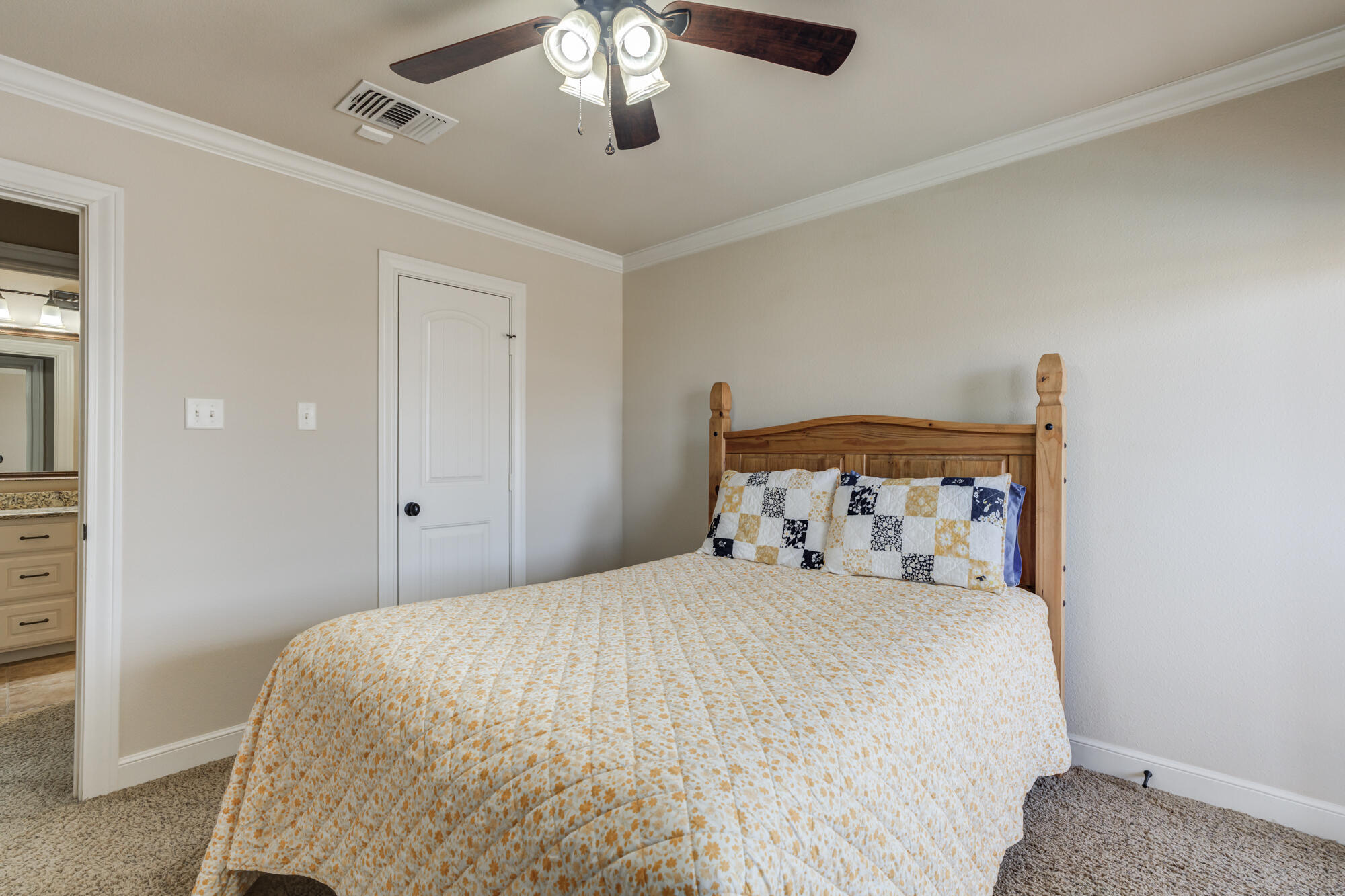 3206 County Road 7610 Lubbock, TX 79423 - Photo 45 of 93 a bedroom with a bed and a chandelier