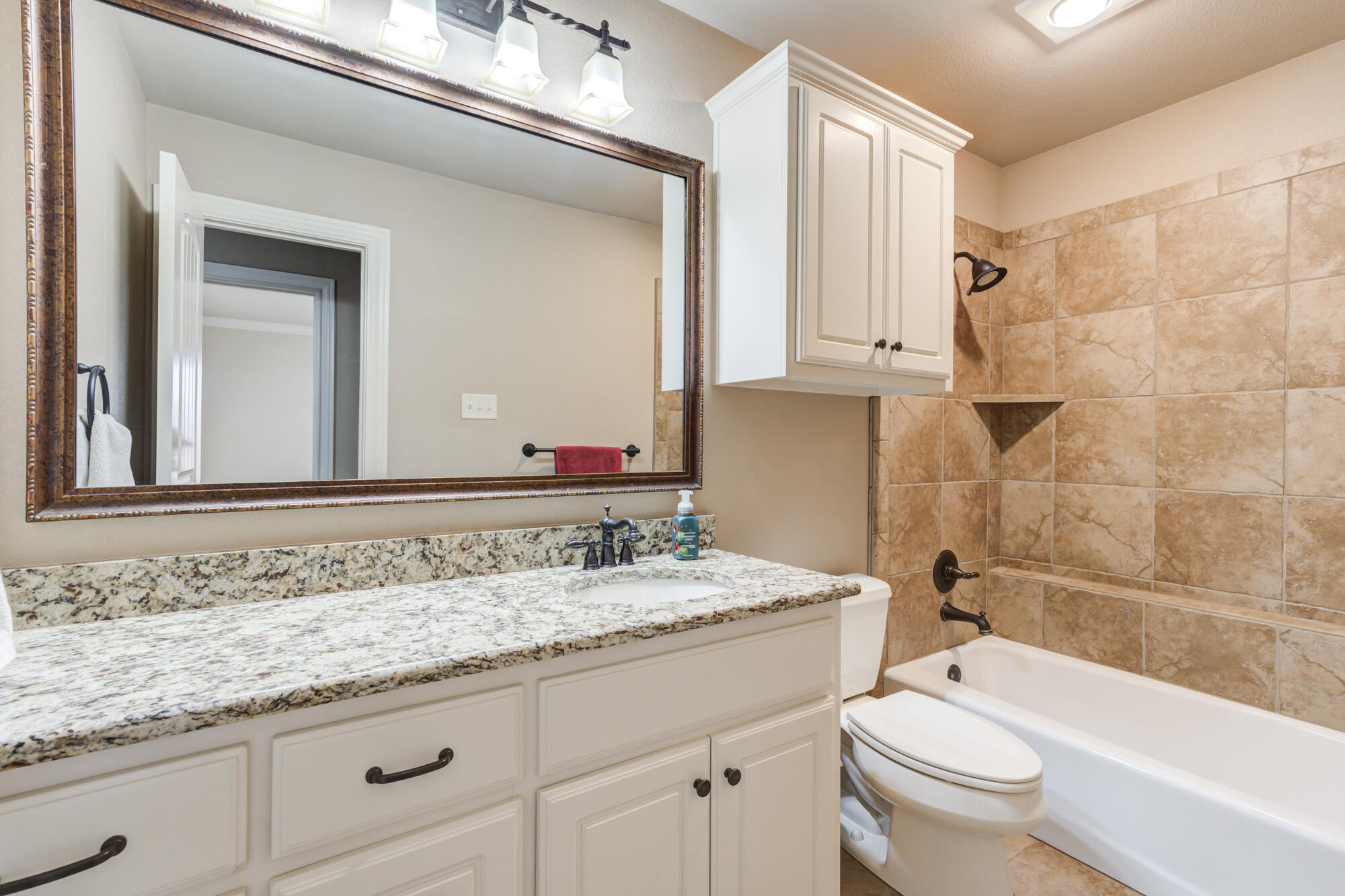 3206 County Road 7610 Lubbock, TX 79423 - Photo 49 of 93 a bathroom with a granite countertop sink a toilet and a bathtub