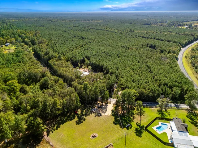 an aerial view of residential houses with outdoor space and trees
