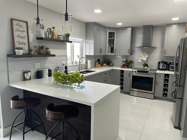 a kitchen with a sink a stove and chairs