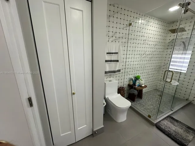 a bathroom with a granite countertop toilet and a shower