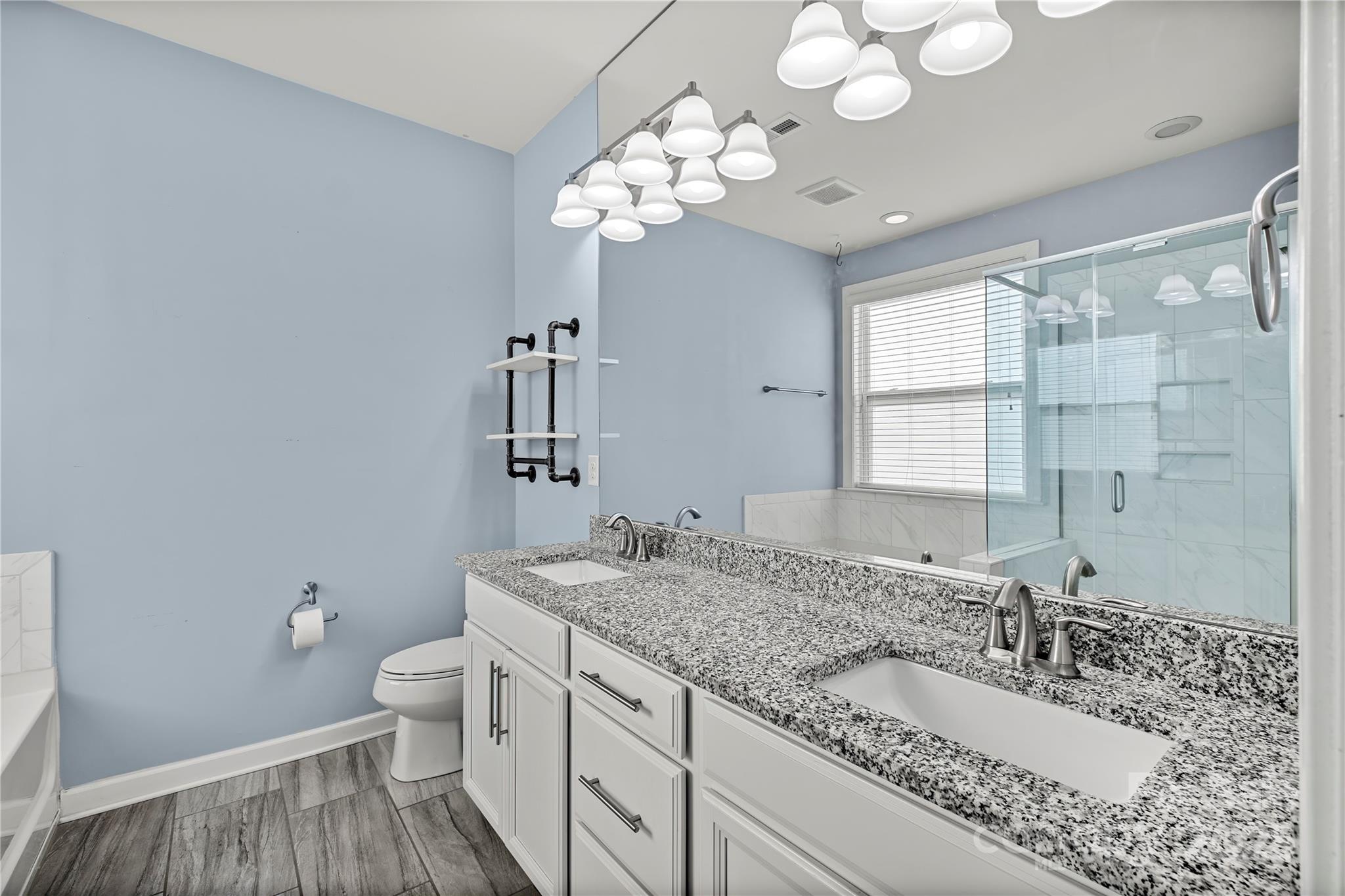 2830 Berkhamstead Circle Concord, NC 28027 - Photo 16 of 27 a bathroom with a granite countertop double vanity sink a mirror and a toilet