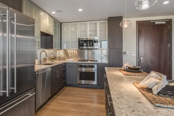 a kitchen with kitchen island granite countertop a stove and a refrigerator