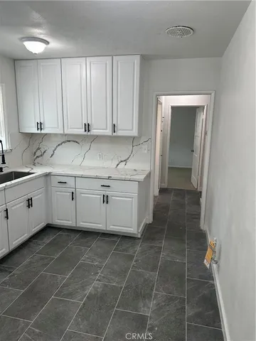 a kitchen with a sink a stove and cabinets