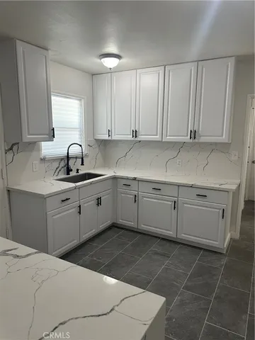 a kitchen with a sink a stove and cabinets