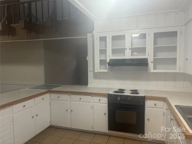 a kitchen with white cabinets and a stove