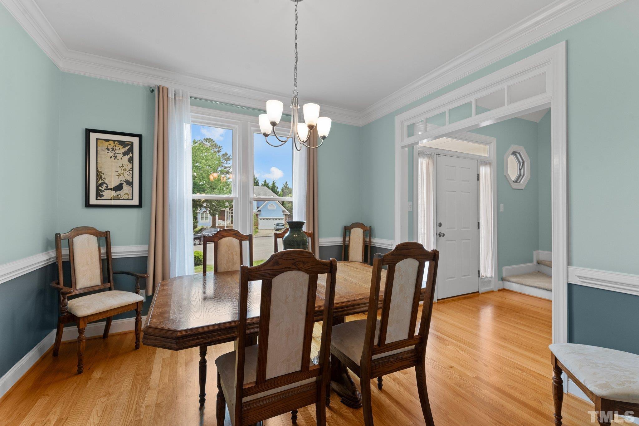 3812 Evander Way Raleigh, NC 27613 - Photo 11 of 52 a dining room with furniture a chandelier and wooden floor