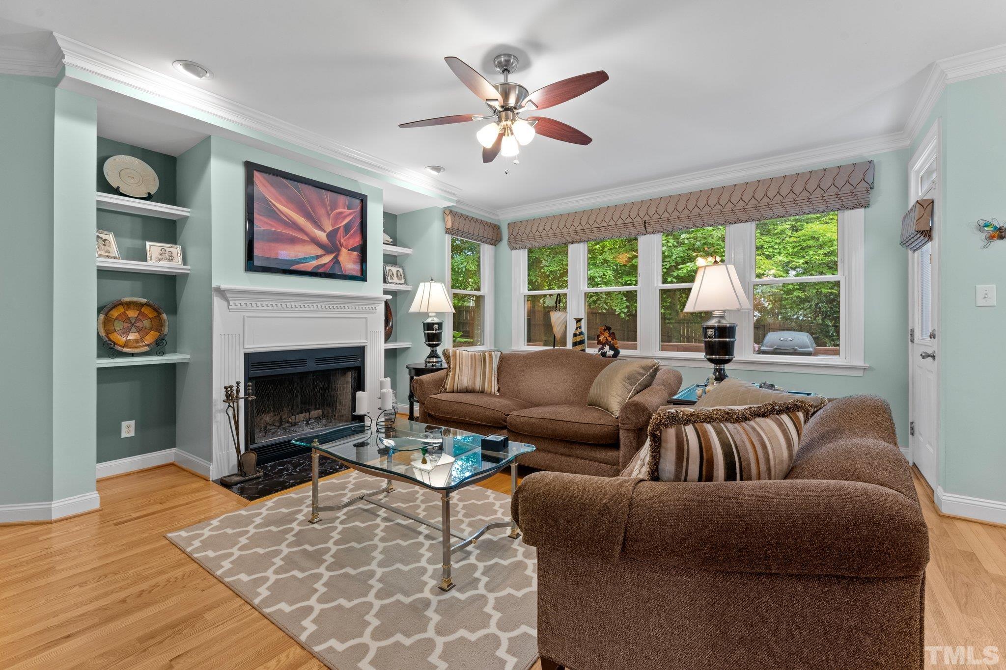 3812 Evander Way Raleigh, NC 27613 - Photo 15 of 52 a living room with furniture a fireplace and a floor to ceiling window