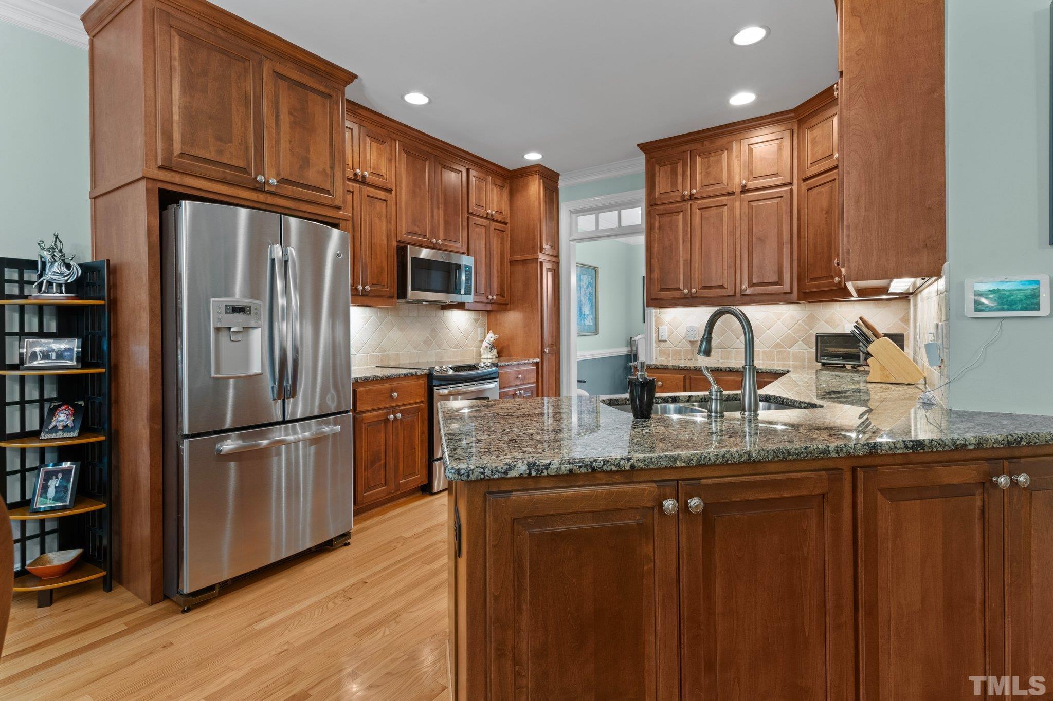 3812 Evander Way Raleigh, NC 27613 - Photo 17 of 52 a kitchen with stainless steel appliances granite countertop a refrigerator a sink and a stove