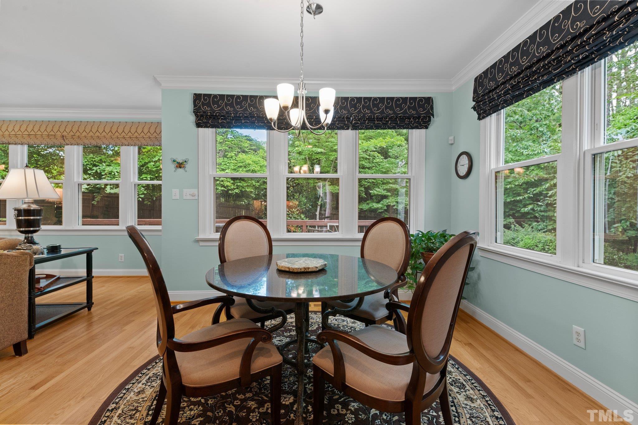 3812 Evander Way Raleigh, NC 27613 - Photo 21 of 52 a dining room with furniture a chandelier and wooden floor