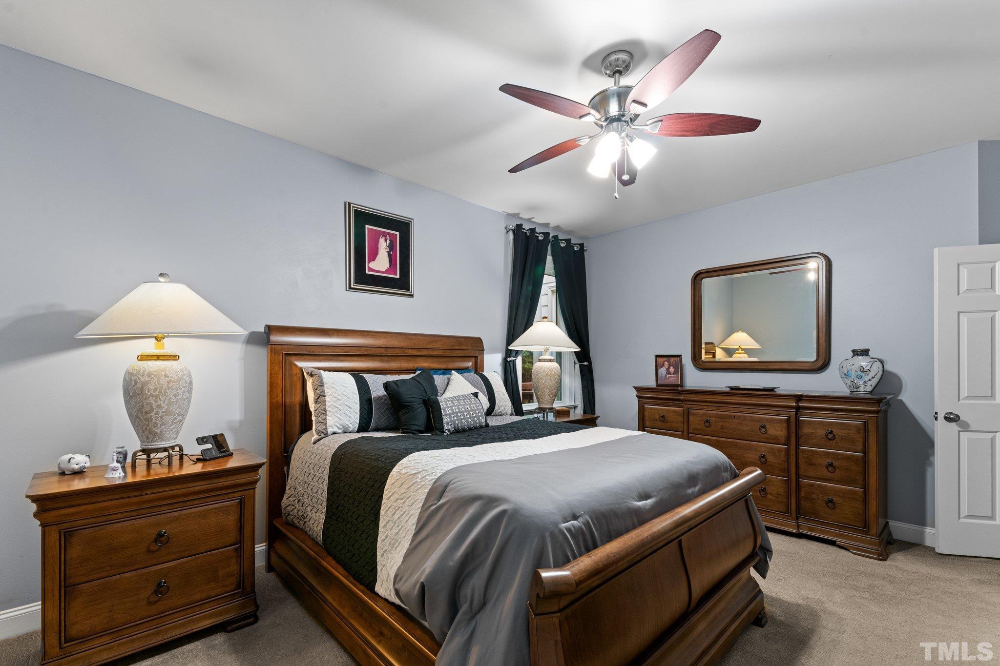 3812 Evander Way Raleigh, NC 27613 - Photo 23 of 52 a bedroom with bed and a chandelier