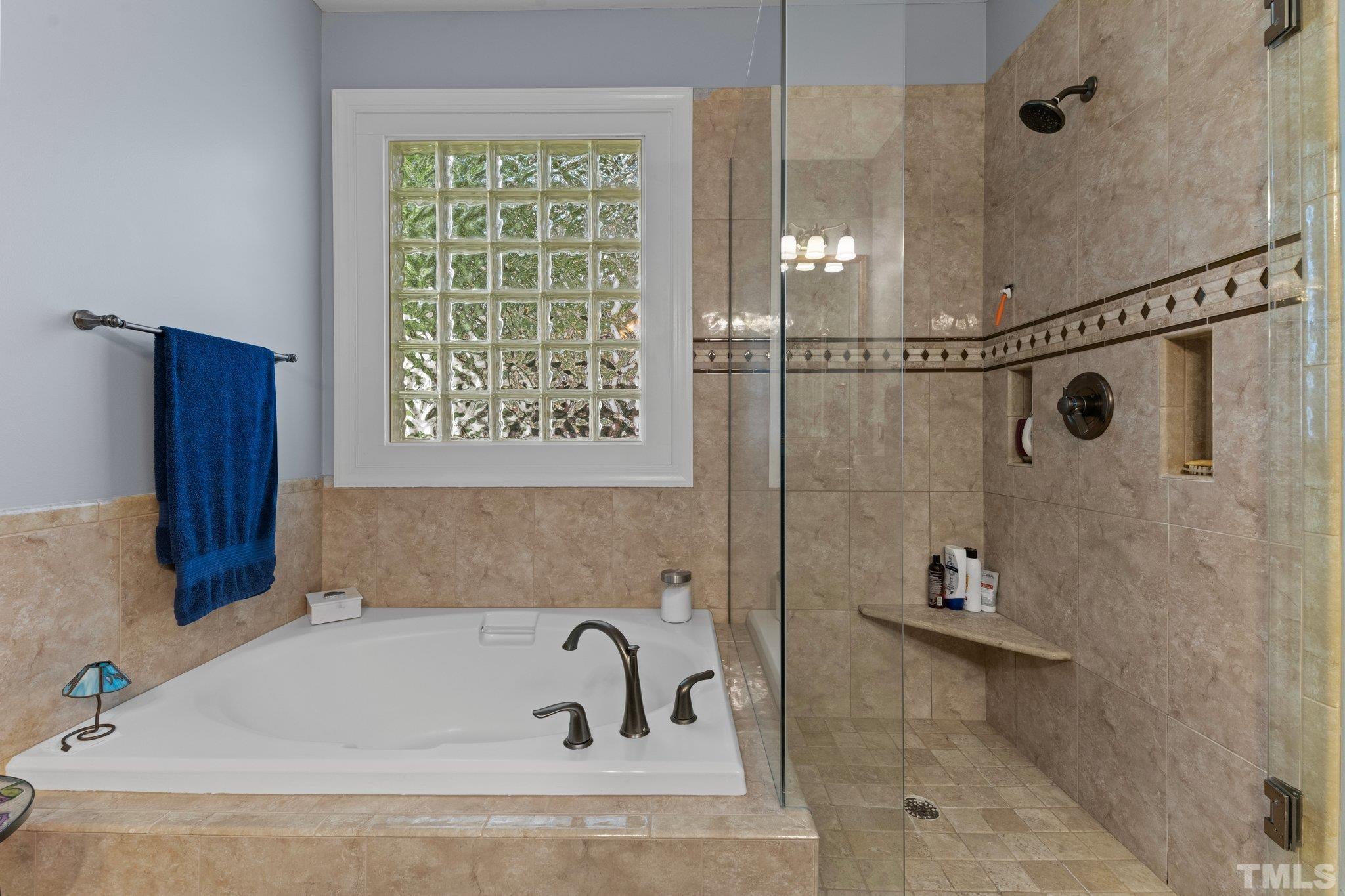 3812 Evander Way Raleigh, NC 27613 - Photo 25 of 52 a bathroom with a tub and a shower