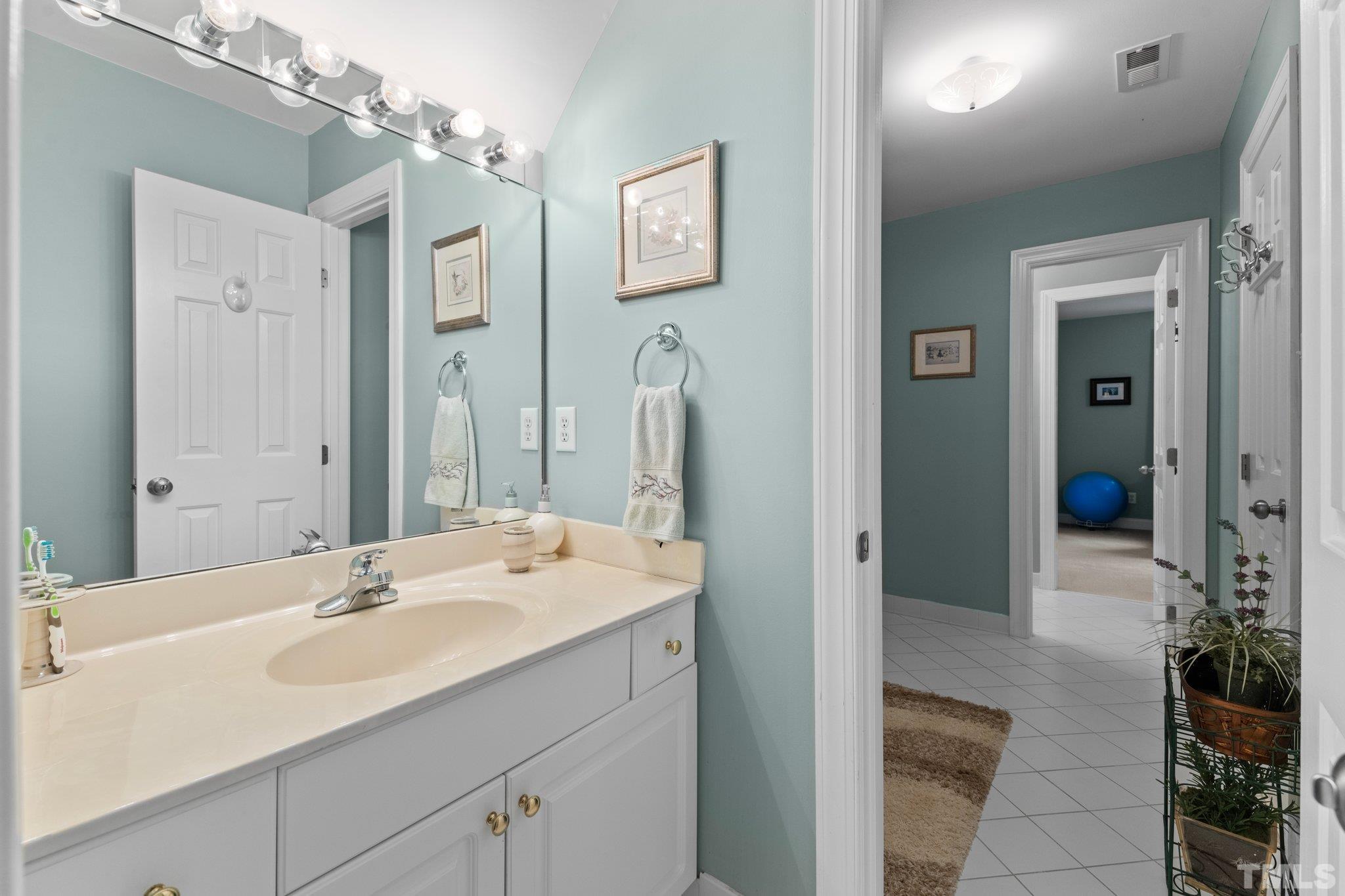 3812 Evander Way Raleigh, NC 27613 - Photo 32 of 52 a en suite bathroom with a sink and a mirror