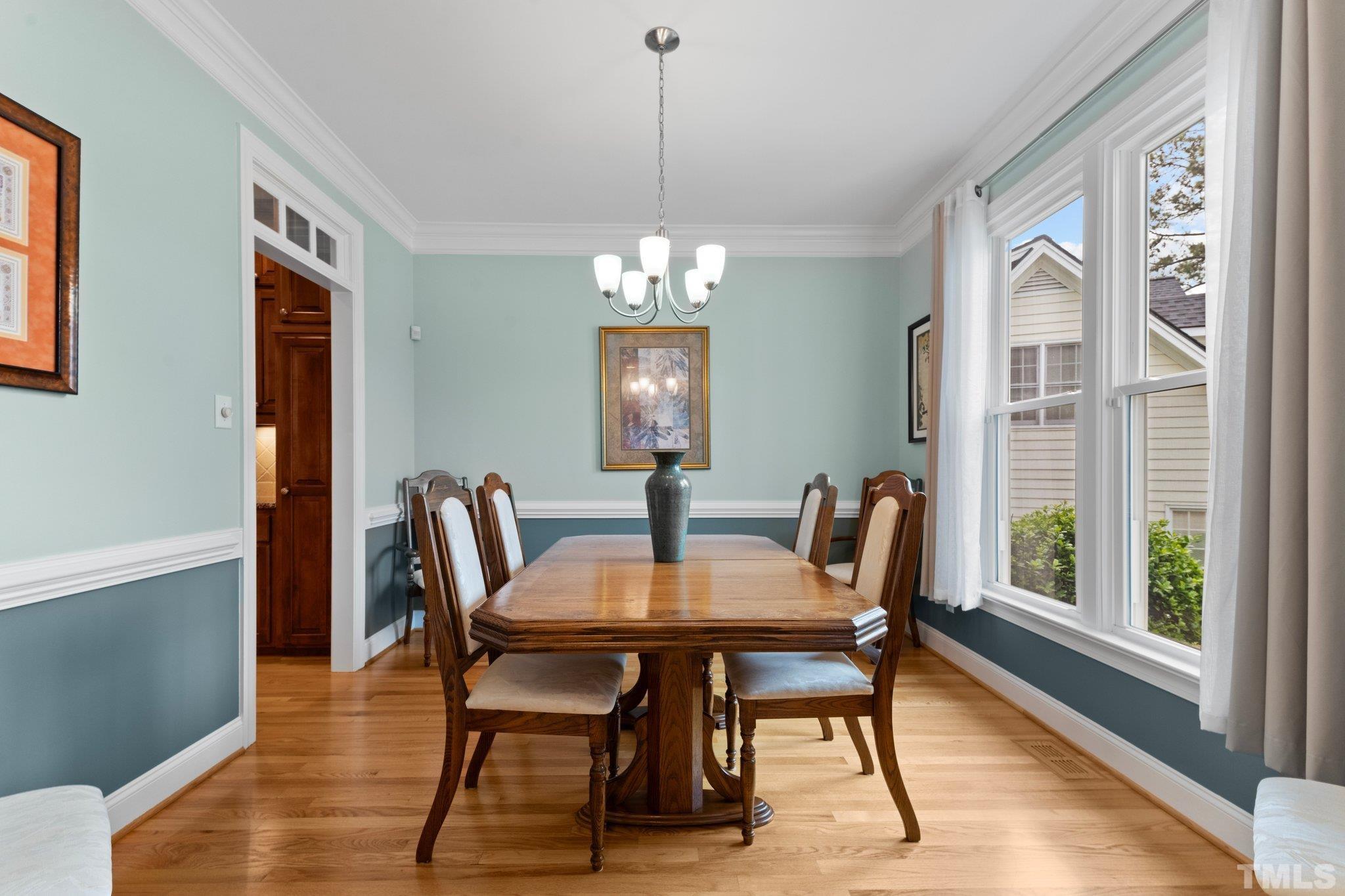 3812 Evander Way Raleigh, NC 27613 - Photo 10 of 52 a dining room with furniture a chandelier and wooden floor