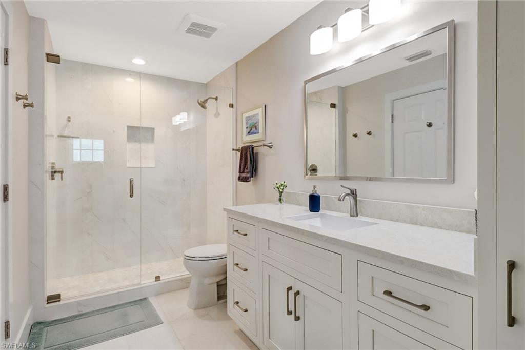 401 Bayfront Place, Unit 3306 Naples, FL 34102 - Photo 11 of 26 a spacious bathroom with a shower sink mirror and toilet
