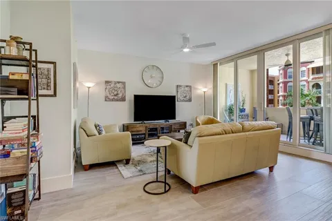 a living room with furniture a large window and a flat screen tv