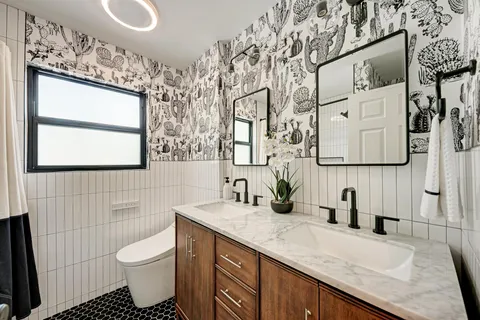 a bathroom with a granite countertop sink toilet and mirror