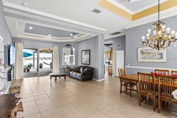 a living room with furniture a dining table and a chandelier