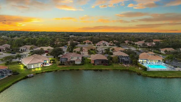 an aerial view of residential houses with outdoor space and lake view
