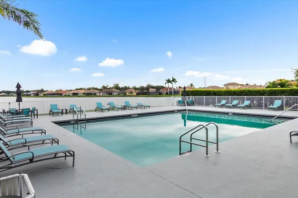 a view of a swimming pool with outdoor seating and a ocean view