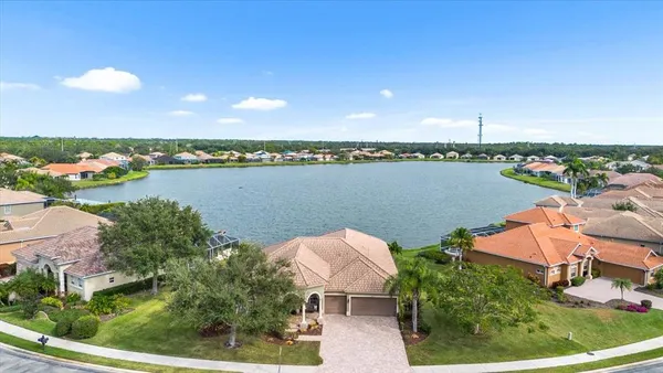an aerial view of a house with a garden and lake view
