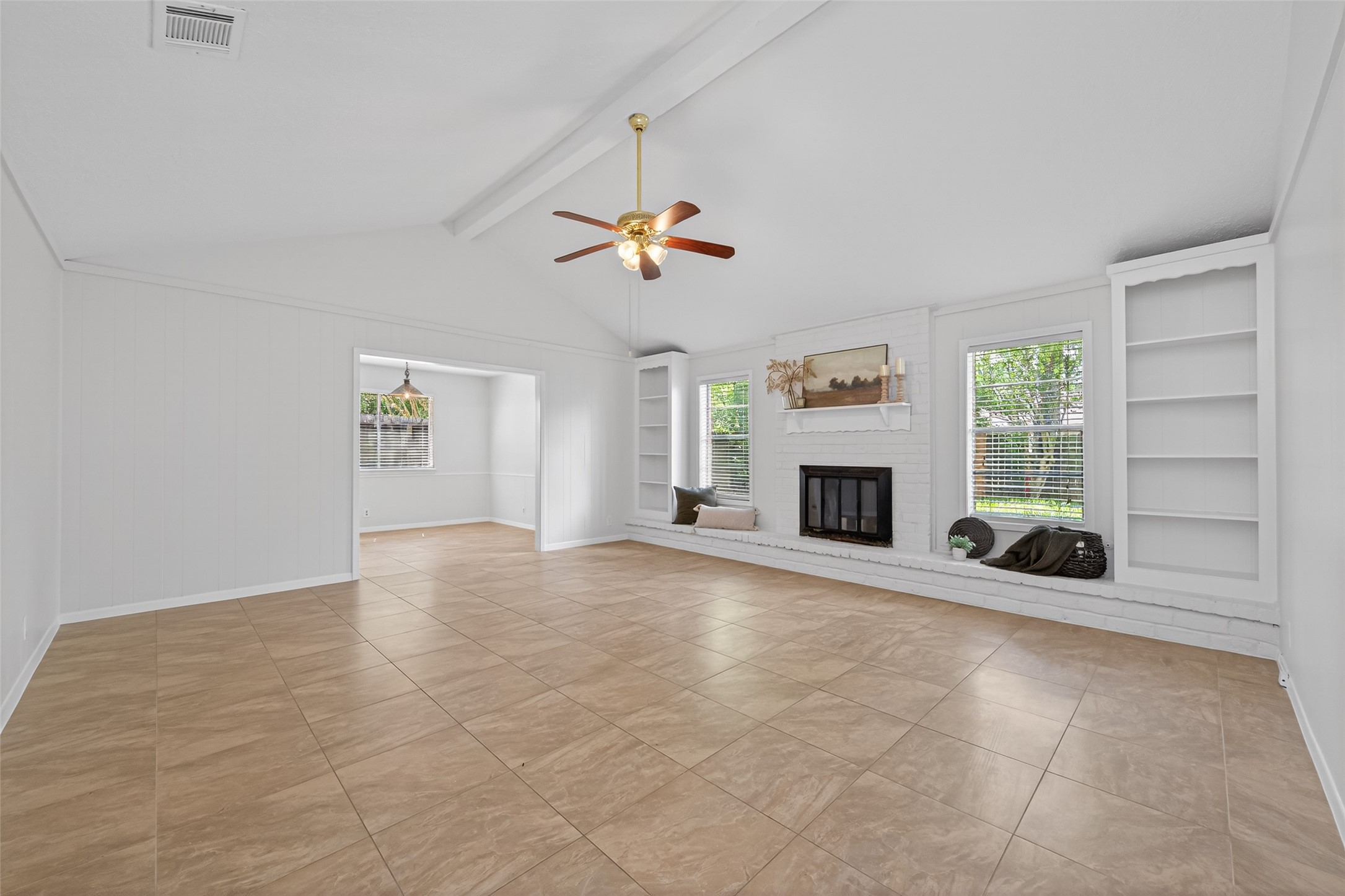 23919 Farm Hill Drive Spring, TX 77373 - Photo 8 of 41 an empty room with windows fireplace and a chandelier fan