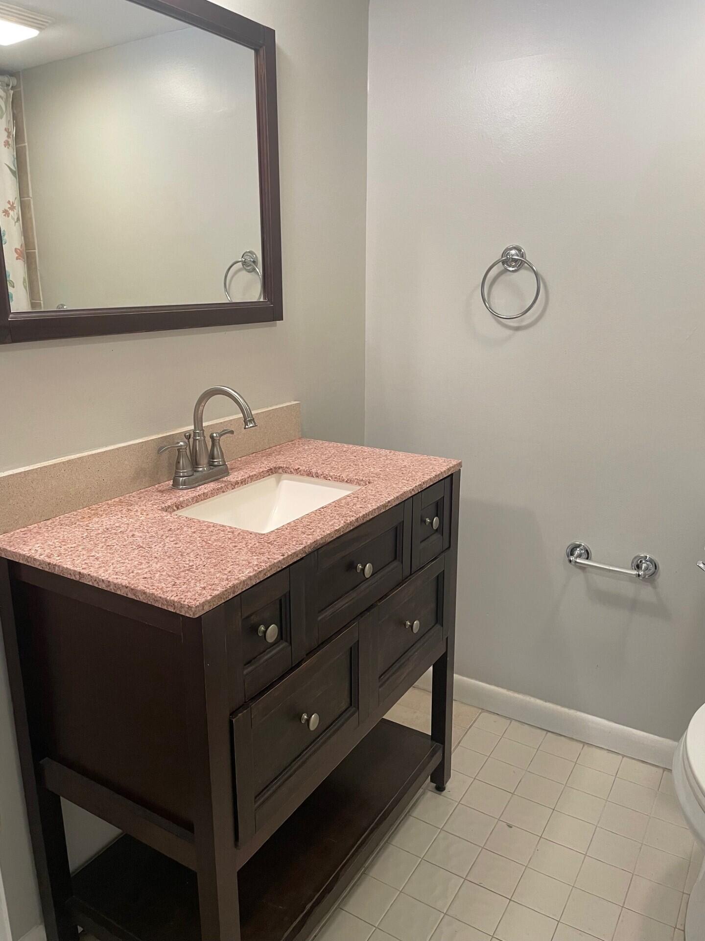 1271 Southeast Parkview Place, Unit H8 Stuart, FL 34994 - Photo 11 of 13 a bathroom with a sink vanity and a mirror