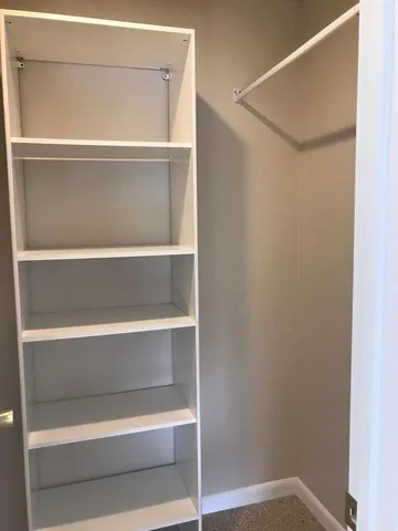 a view of walk in closet with empty racks
