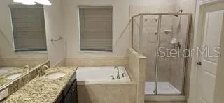 a bathroom with a granite countertop sink a mirror and shower