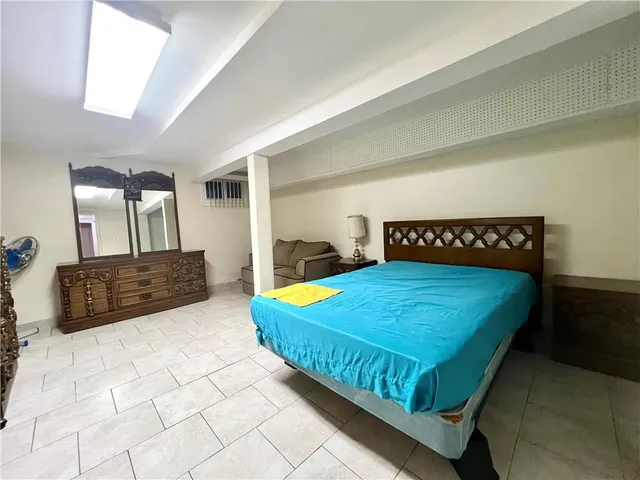 a bedroom with a large bed and a large mirror