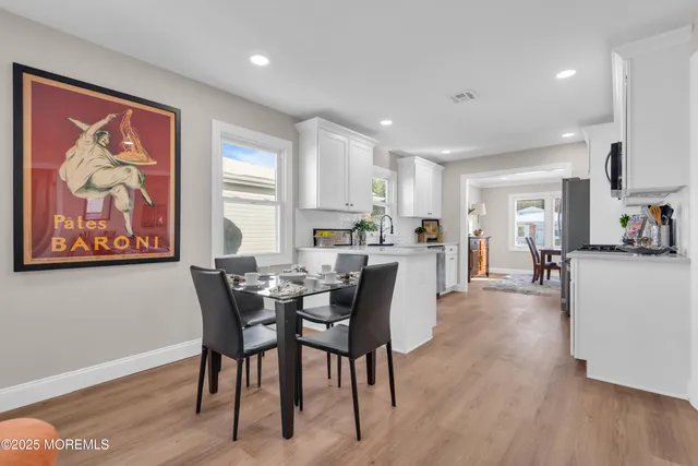 a living room with furniture kitchen view and a flat screen tv