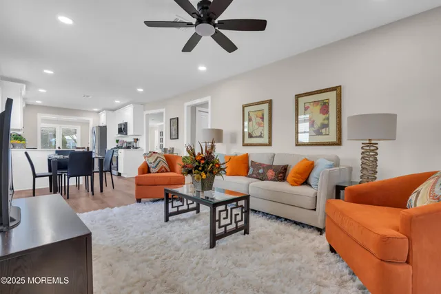 a living room with furniture kitchen view and a window