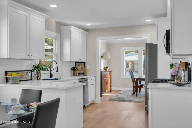 a kitchen with stainless steel appliances granite countertop sink stove top oven and cabinets