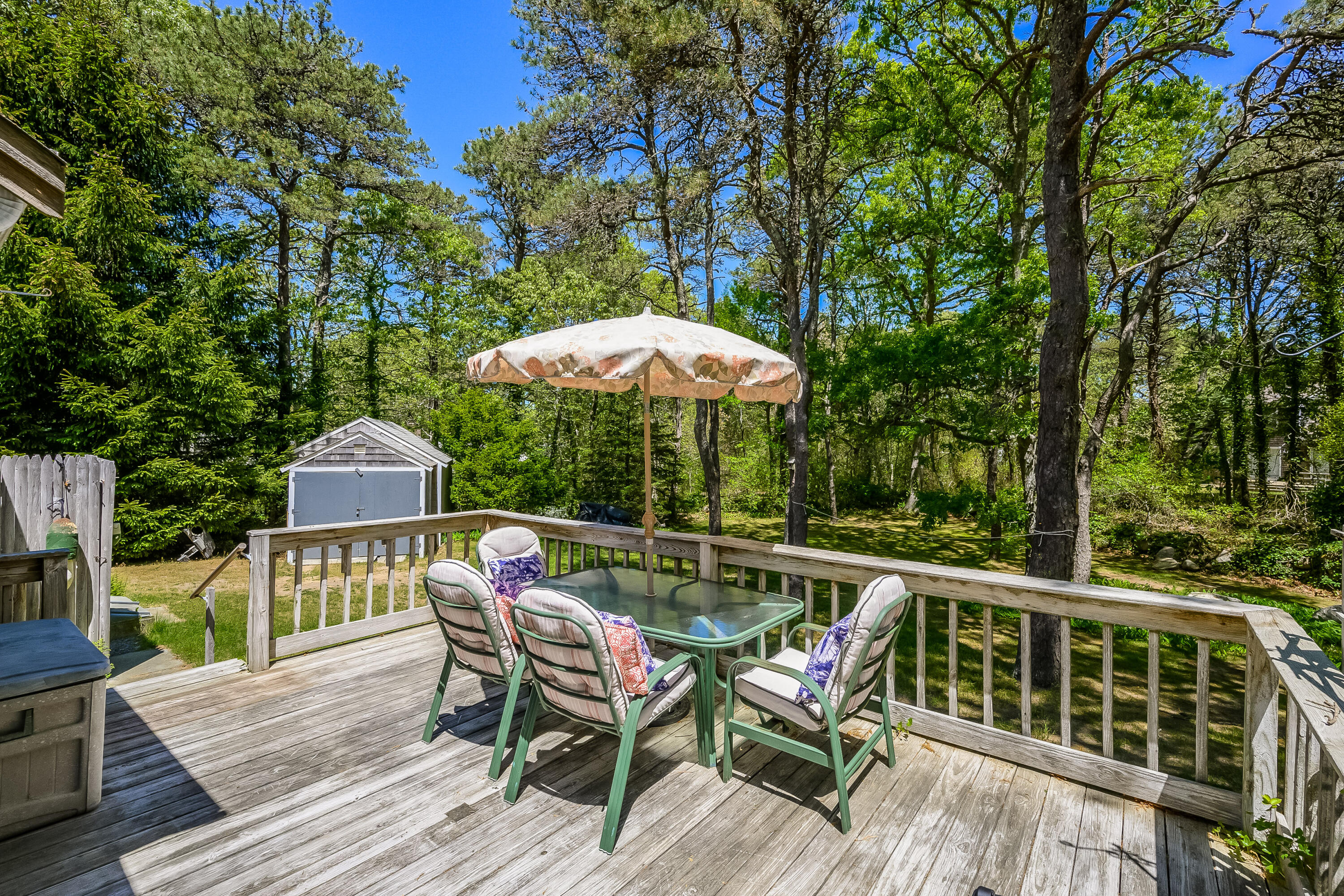 106 Tower Hill Circle Brewster, MA 02631 - Photo 16 of 19 a patio with wooden floor a yard a table and chairs