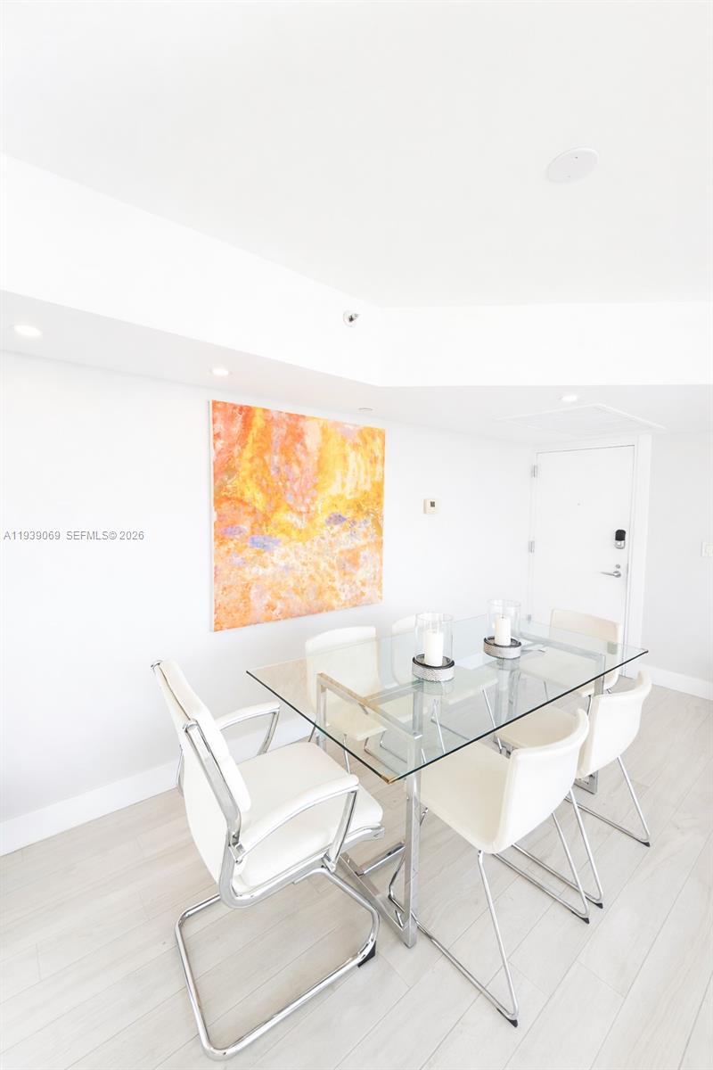 5900 Collins Avenue, Unit 1405 Miami Beach, FL 33140 - Photo 10 of 38 a dining room with furniture and a floor to ceiling window