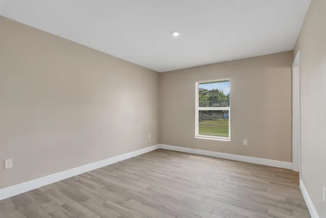 wooden floor in an empty room with a window