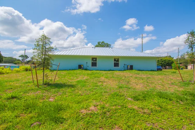 a yellow building in the middle of a yard