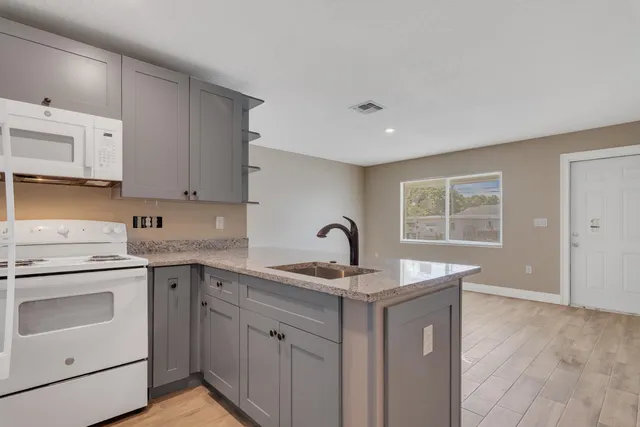 a kitchen that has a sink a stove and window