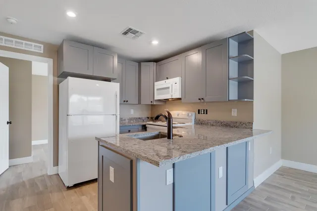 a kitchen with kitchen island granite countertop counter top space cabinets and stainless steel appliances