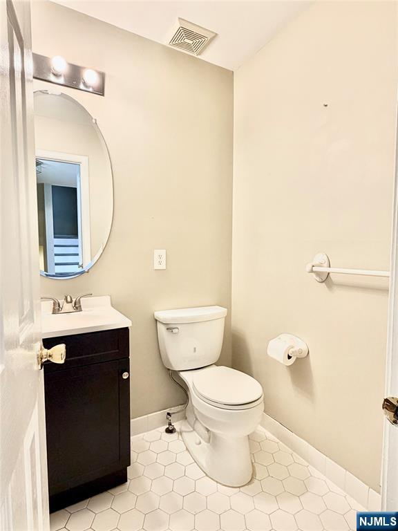 35 Harrier Court, Unit 35 Wayne, NJ 07470 - Photo 2 of 16 a bathroom with a toilet sink vanity and mirror