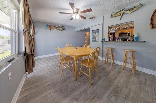 a view of a dining room with furniture a chandelier and wooden floor