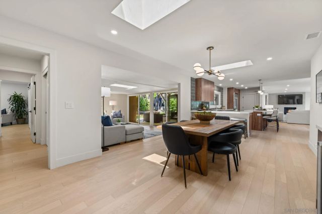 a kitchen with stainless steel appliances kitchen island granite countertop a table chairs and a refrigerator