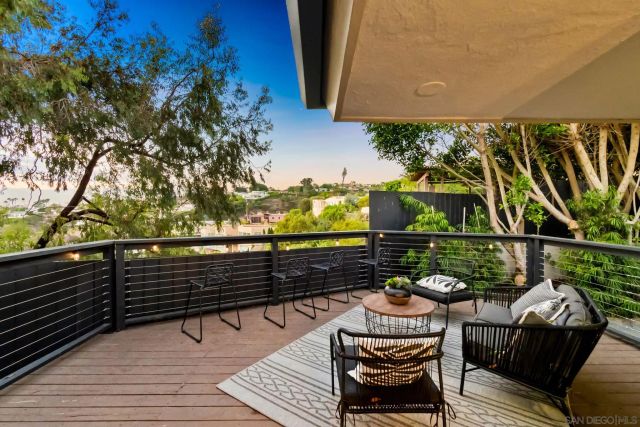 a view of a balcony with chairs and wooden floor
